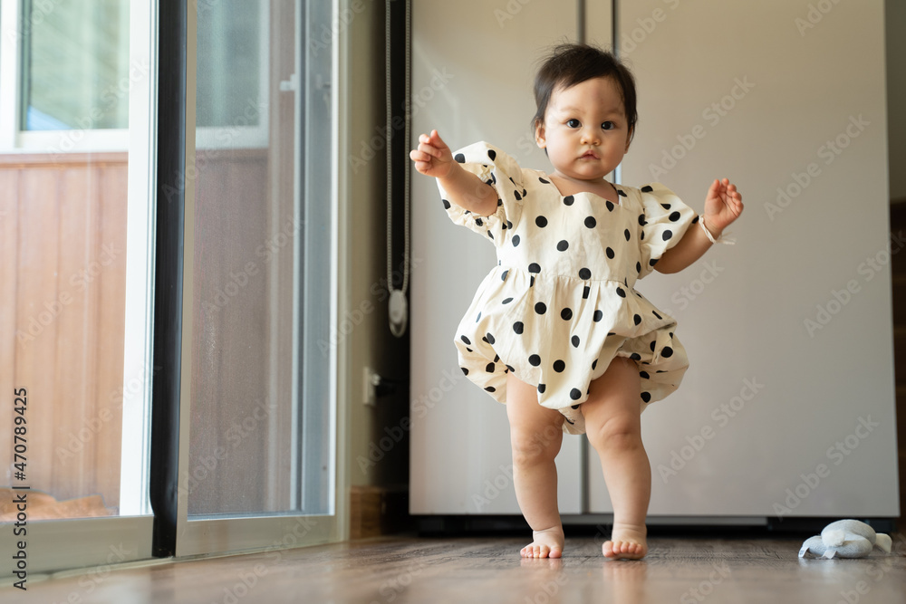 asian baby infant toddler trying to walk at home. child put effort learning to walk. authentic life at home.