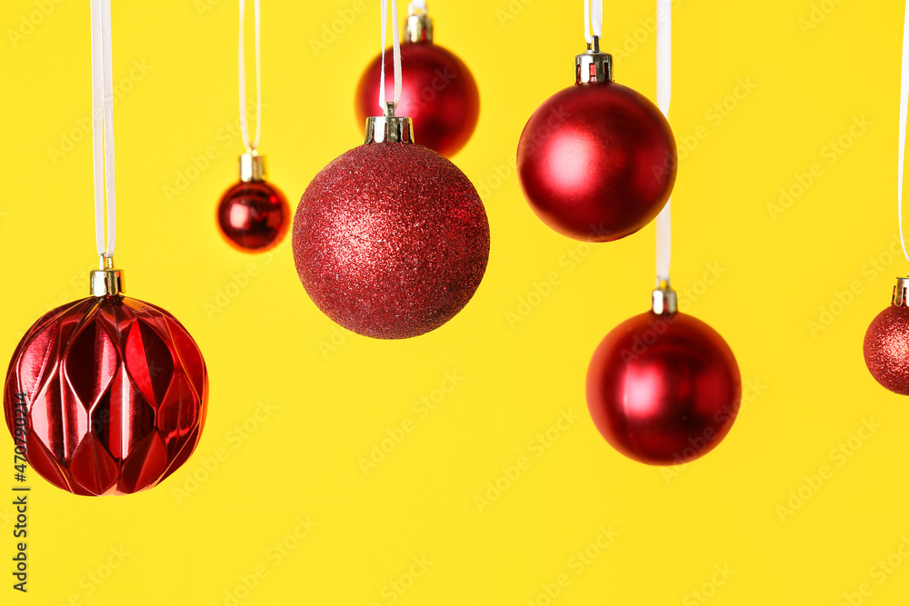 Red Christmas balls on yellow background, closeup Red Christmas balls on yellow background, closeup