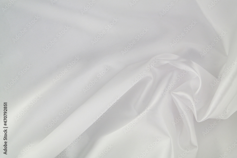 White satin or silk fabric as background. Elegant wallpaper, wedding backdrop or design element.	