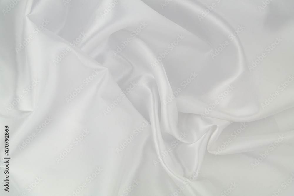 White satin or silk fabric as background. Elegant wallpaper, wedding backdrop or design element.	