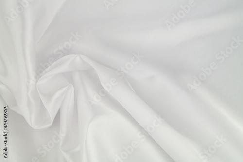 White satin or silk fabric as background. Elegant wallpaper, wedding backdrop or design element. 