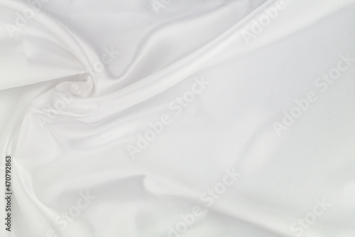 White satin or silk fabric as background. Elegant wallpaper, wedding backdrop or holidays design element. 