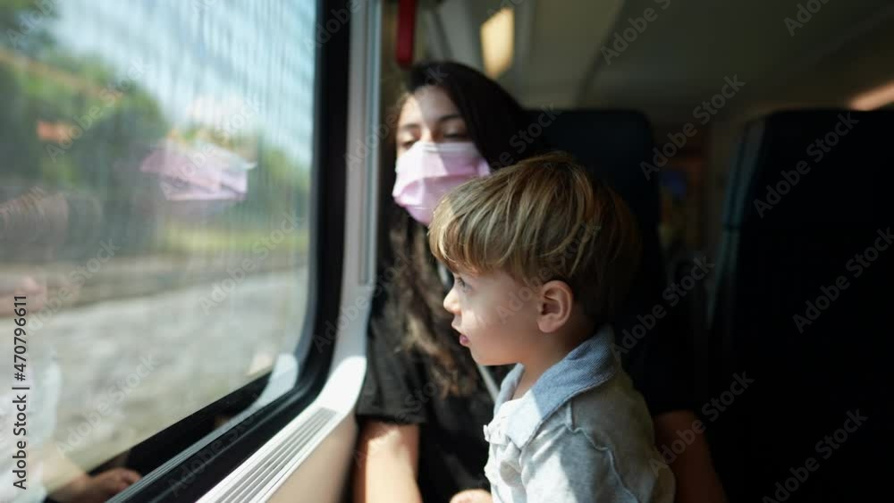 Mother and child riding train wearing covid-19 face mask Mother and child riding train wearing covid-19 face mask