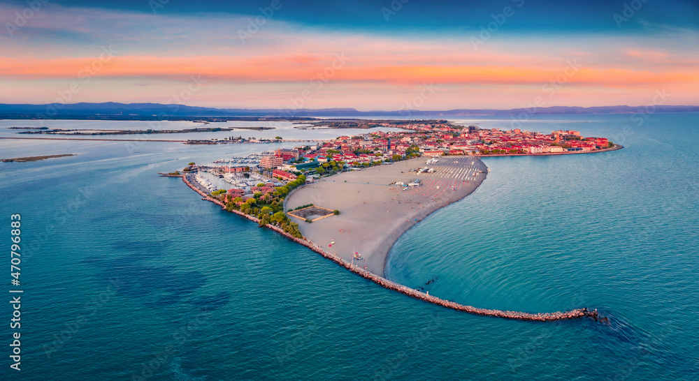 Beautiful summer scenery. Breathtaking summer view from flying drone of public beach of Grado port, small town located between Venice and Trieste. Magnificent evening seascape of Adriatic sea.