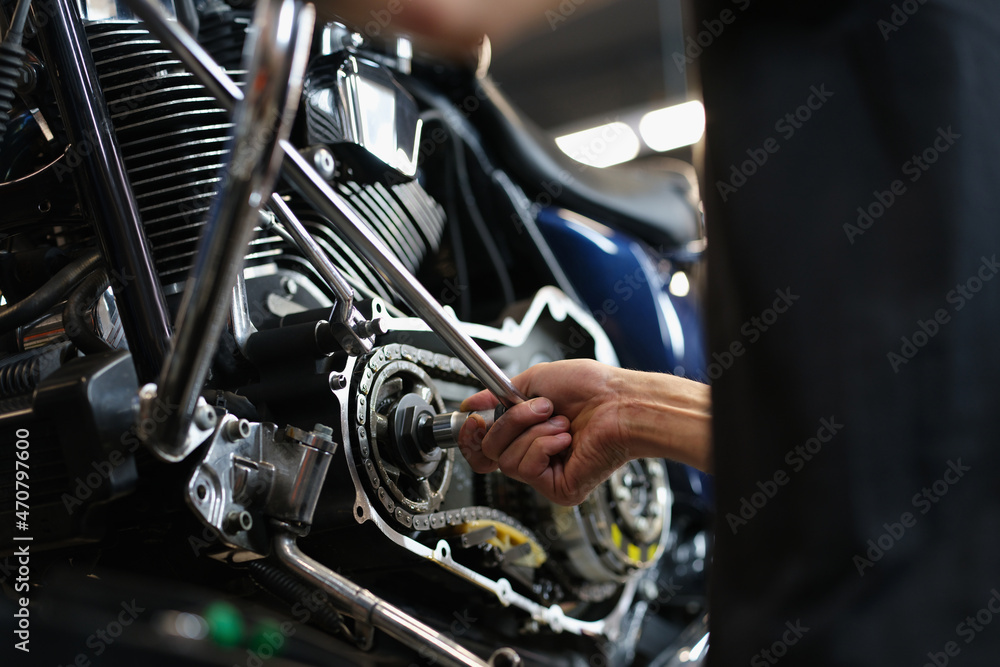 Professional mechanic repair some part of motorbike with equipment - obrazy, fototapety, plakaty 