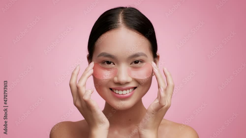 Korean Lady Applying Patches Under Eyes Moisturizing Skin, Pink Background Korean Lady Applying Patches Under Eyes Moisturizing Skin, Pink Background