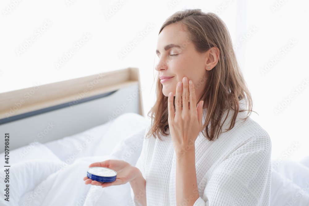 Beautiful caucasian woman applying moisturizer cream on face Beautiful caucasian woman applying moisturizer cream on face