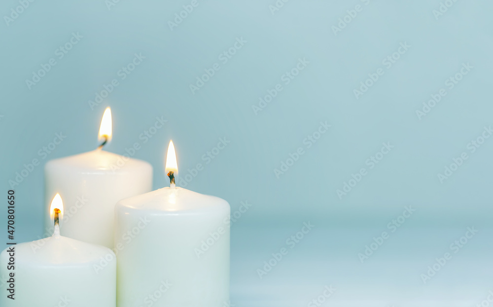 Panorama of three white candles burning on white gradient background. Front view. Horizontal composition. Set of white candles over white background with copy space Panorama of three white candles burning on white gradient background. Front view. Horizontal composition. Set of white candles over white background with copy space