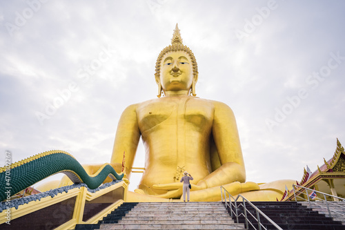 Female tourists admire the majesty of the Big Golden Buddha at Wat Muang  Ang Thong Province  Thailand.