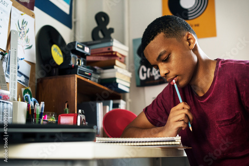 Photography Teenage boy in a bedroom doing work thinking