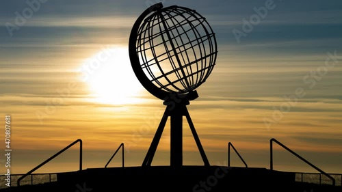 Nordkapp: Time Lapse at Sunset with Colorful Clouds and Silhouette of Globe Monument at North Cape, Norway photo