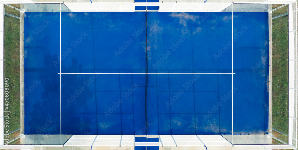 View from above, stunning aerial view of an empty blue padel court. Padel is a mix between Tennis and Squash. It's usually played in doubles on an enclosed court.
