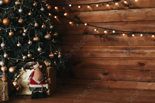 Christmas decorations for the home with a Christmas tree, garlands and gifts, winter traditional holiday. New Year's interior with a wooden background, on which garlands are burning. Lifestyle, cozy