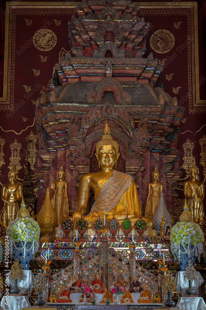 Ancient golden Buddha statues with traditional Lanna style decor inside main vihara at historic Wat Chiang Man buddhist temple, the oldest in Chiang Mai, Thailand
