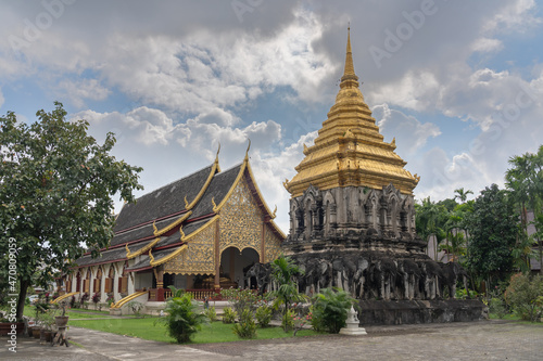 Landscape view of Chedi Chang Lom stupa with vihara in background at historic ancient Lanna style Wat Chiang Man buddhist temple, the oldest in Chiang Mai, Thailand