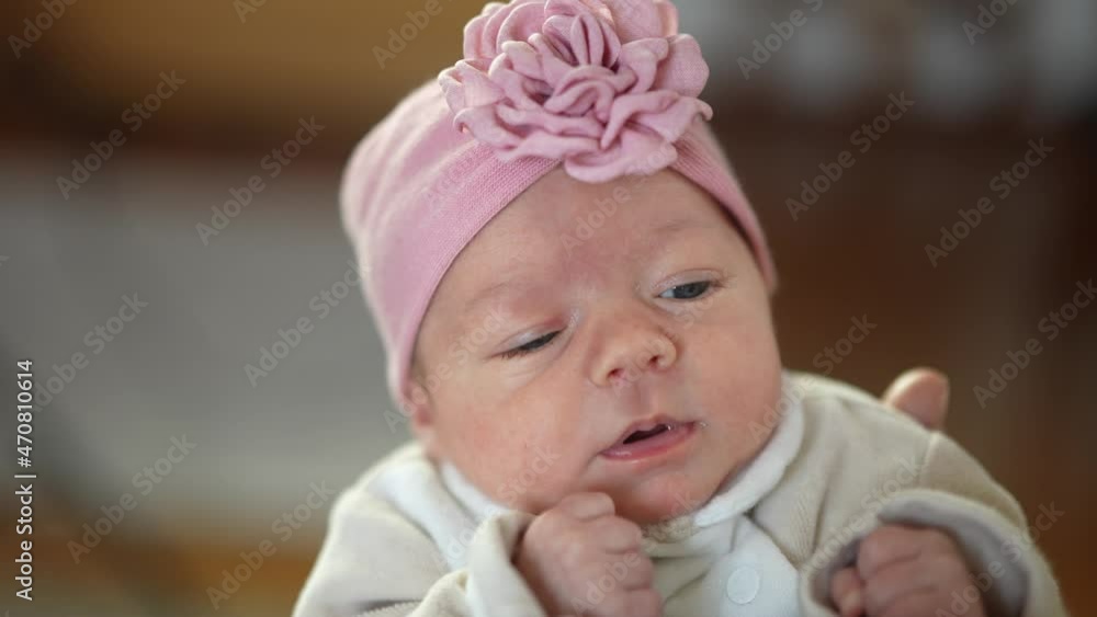 Portrait of a pretty cute newborn baby girl with a pink trendy headband. Portrait of a pretty cute newborn baby girl with a pink trendy headband.