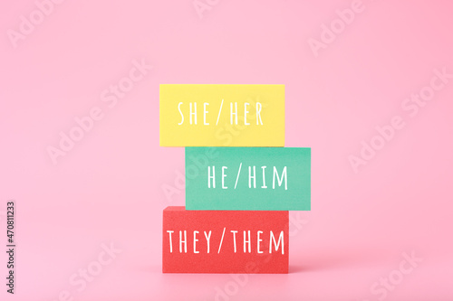 Correct pronouns for different genders hand written on multicolored rectangles against bright pink background. Concept of Lgbtq plus, transgender and bigender tolerance, respect and equal rights photo