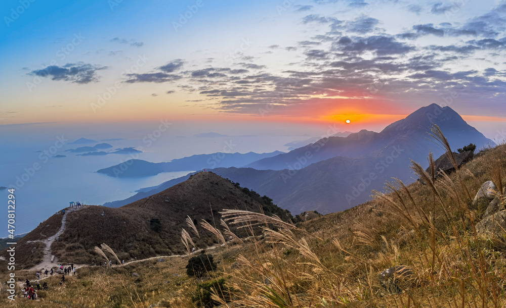 sunset over field of Imperata cylindrica, or cogongrass or kunai grass at Sunset Peak or Tai Tung Shan in Lantau Island, Hong Kong