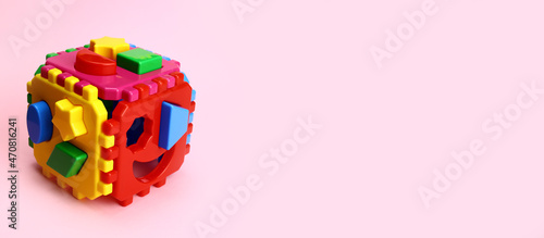 Photos Children's educational game cube sorter on a pink background
