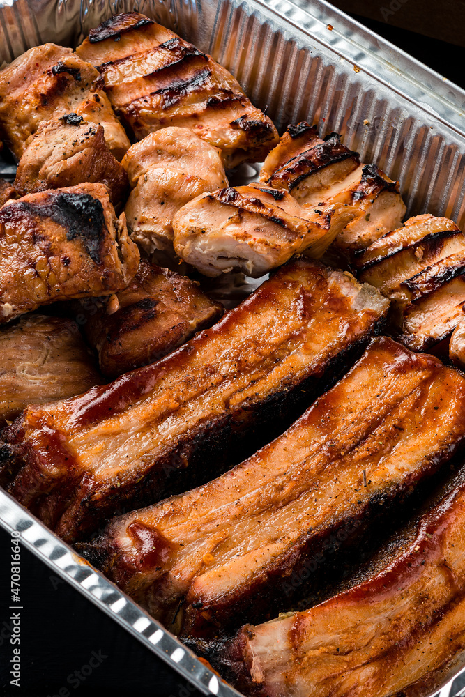 set of grilled ribs and BBQ meat in a delivery box