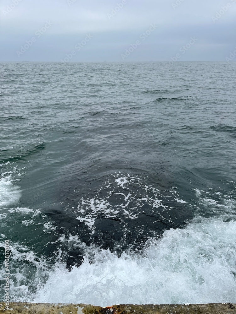 Waves washing over concrete pier in the sea Waves washing over concrete pier in the sea