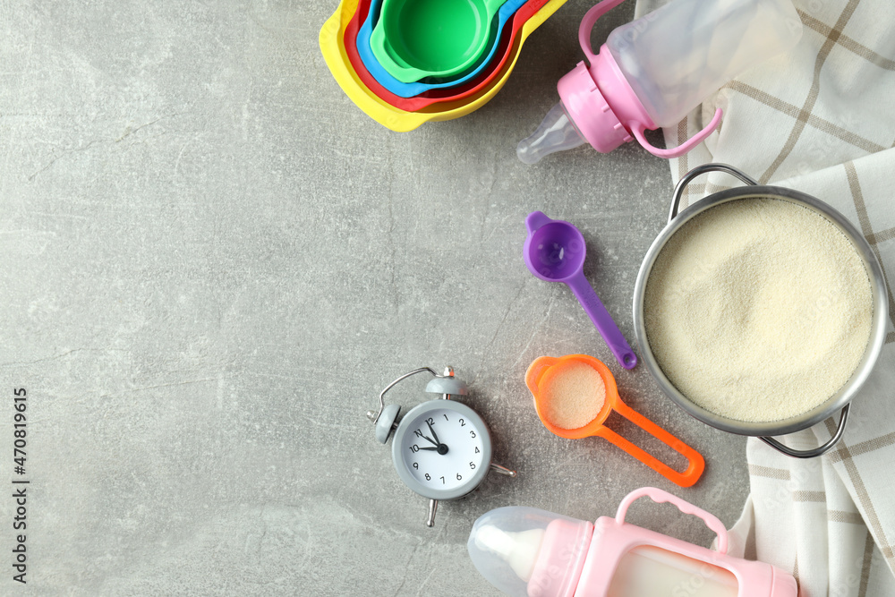 Concept of baby food with рowdered milk on gray textured background Concept of baby food with рowdered milk on gray textured background