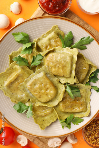 Delicious food concept with ravioli on orange background