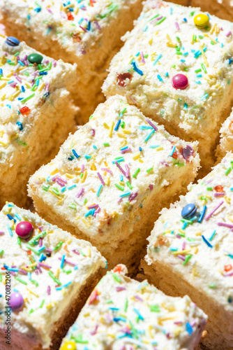 Sliced Sponge Cake DEcorated With Cream and Sprinkles. Closeup View