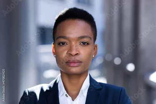 Headshot photo with close up portrait of serious businesswoman, african american woman confident and focused looking at camera