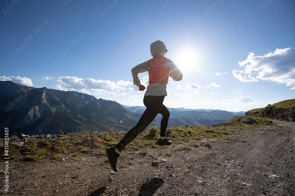 Woman trail runner running at mountain top Woman trail runner running at mountain top