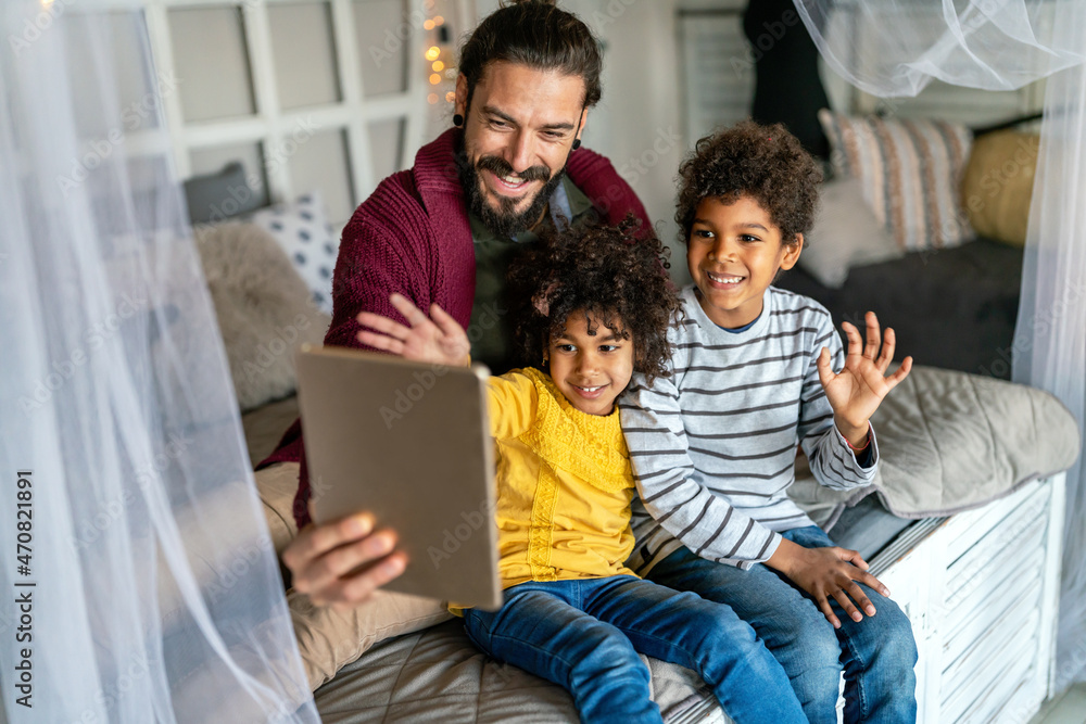 Happy father and children playing with digital tablet. Multiethnic family fun technology concept Happy father and children playing with digital tablet. Multiethnic family fun technology concept