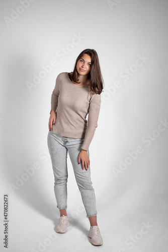 Beautiful woman posing while standing on gray background. Emotions and feelings of a lovely lady.