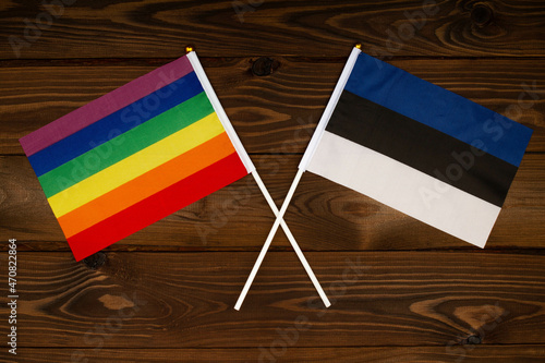 Rainbow flag LGBT and flag of Estonia on beautiful brown background with wooden texture. LGBT Pride Month. LGBTQ. LGBTQIA. Human rights concept. Close Up. Top view