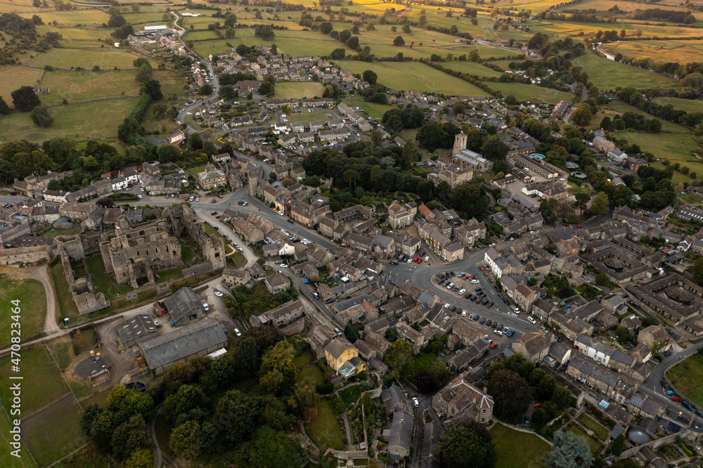 Aerial photo at sunset in the beautiful village of Middleham, Leyburn in North Yorkshire in the UK showing the sun setting over the historical small British village at dusk