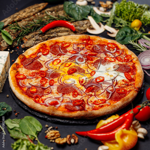 Top view pizza on table top, Flat lay of pizza on black background, Prepared pizza on table for serve Freshly baked homemade pizza isolated on a black background with vegetables. View from above