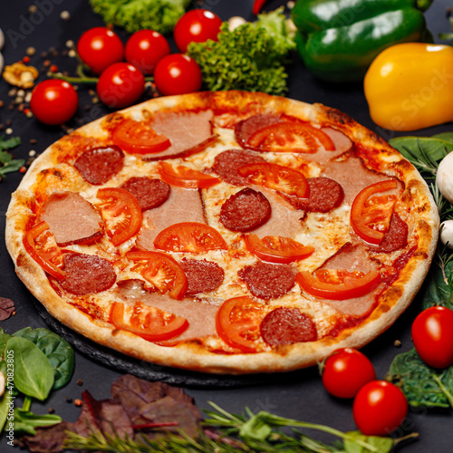 Top view pizza on table top, Flat lay of pizza on black background, Prepared pizza on table for serve Freshly baked homemade pizza isolated on a black background with vegetables. View from above