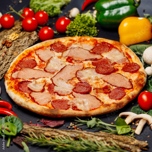 Top view pizza on table top, Flat lay of pizza on black background, Prepared pizza on table for serve Freshly baked homemade pizza isolated on a black background with vegetables. View from above