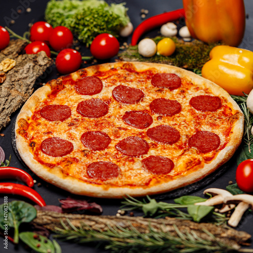 Top view pizza on table top, Flat lay of pizza on black background, Prepared pizza on table for serve Freshly baked homemade pizza isolated on a black background with vegetables. View from above