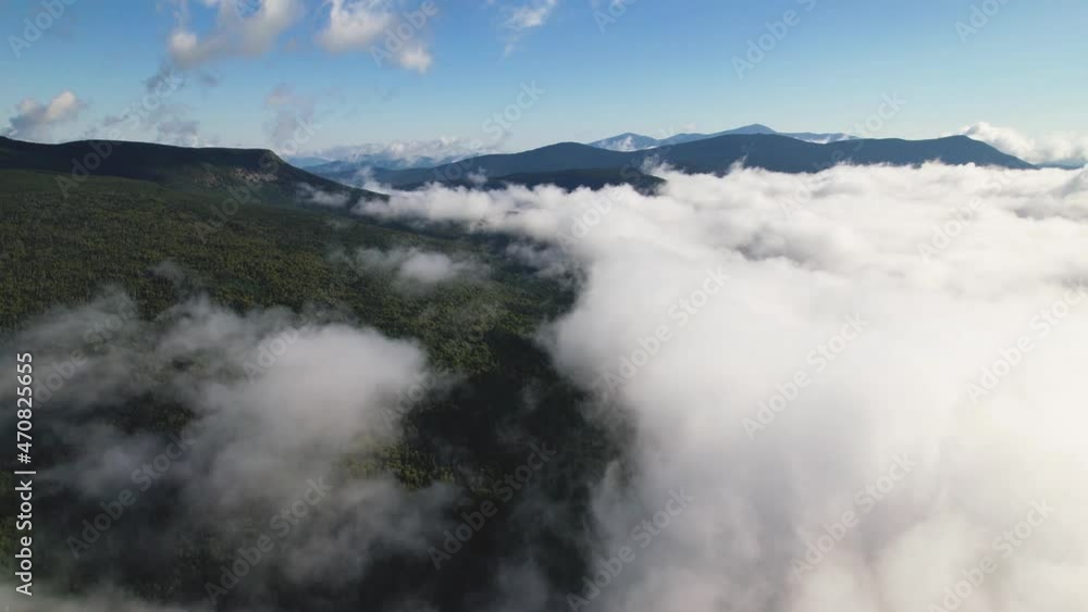 Scenic flight over beautiful mountain scape with bright sky and clouds. Flying high over the forest. Aerial view running clouds over the green forest. Aerial top view cloudscape. Texture of clouds. Scenic flight over beautiful mountain scape with bright sky and clouds. Flying high over the forest. Aerial view running clouds over the green forest. Aerial top view cloudscape. Texture of clouds.