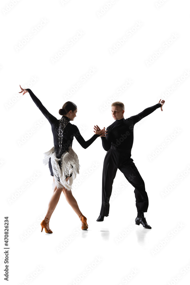 Two young graceful dancers, flexible man and woman dancing ballroom dance isolated on white studio background.