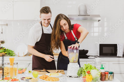 Couple pouring smoothie at table