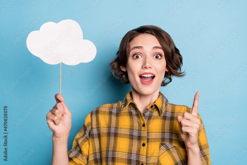 Photo of excited creative lady hold cloud card have great idea wear plaid shirt isolated blue color background Photo of excited creative lady hold cloud card have great idea wear plaid shirt isolated blue color background