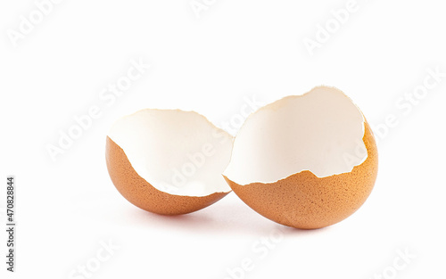 Image of a broken eggshell divided into two pieces of eggshell fragments of a chicken or poultry used for cooking on a white background.