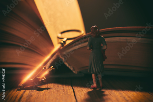abstract image of woman looking at open book with glowing light . Concept of dream and fantasy