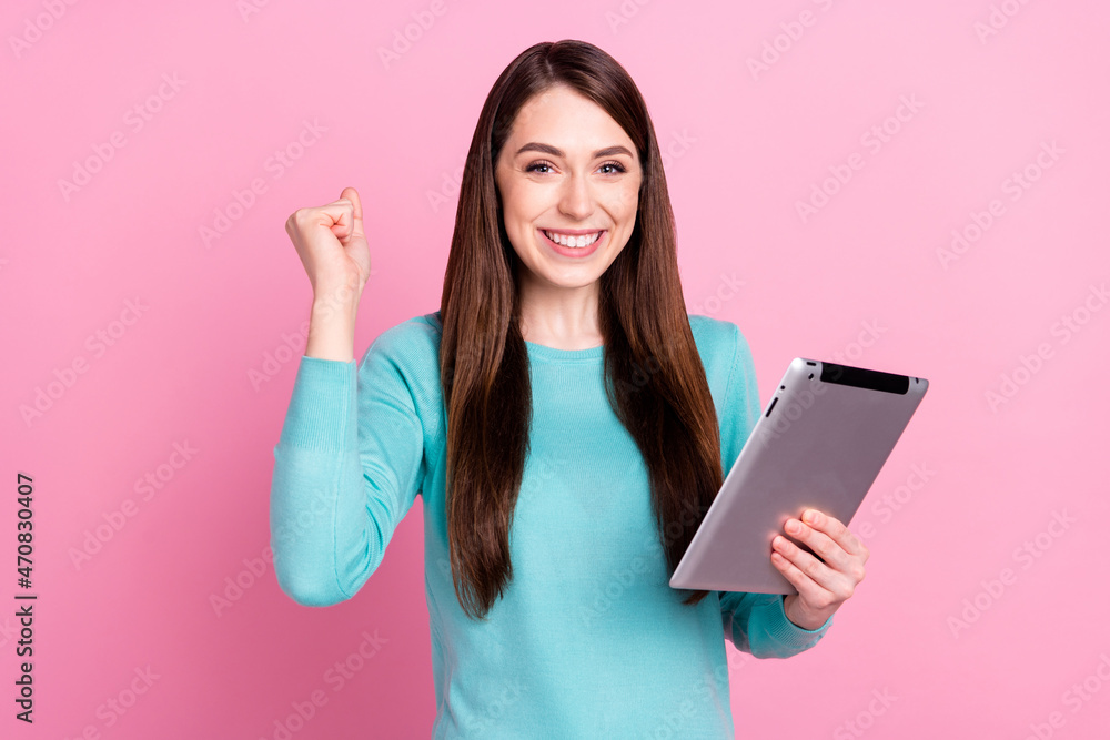 Portrait of attractive lucky cheerful girl holding in hands ebook having fun isolated over pink pastel color background Portrait of attractive lucky cheerful girl holding in hands ebook having fun isolated over pink pastel color background