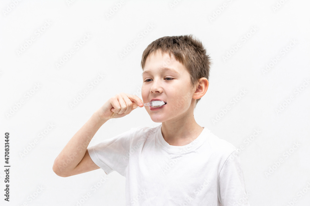 A boy in a white T-shirt is brushing his teeth in the bathroom. A boy in a white T-shirt is brushing his teeth in the bathroom.
