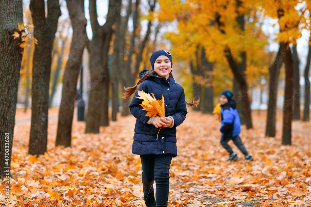 Fototapeta premium Children running in autumn city park. Beautiful nature, trees with yellow leaves.