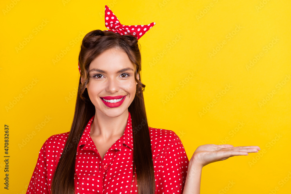 Photo of sweet charming young woman dressed red clothes smiling holding arms empty space isolated yellow color background