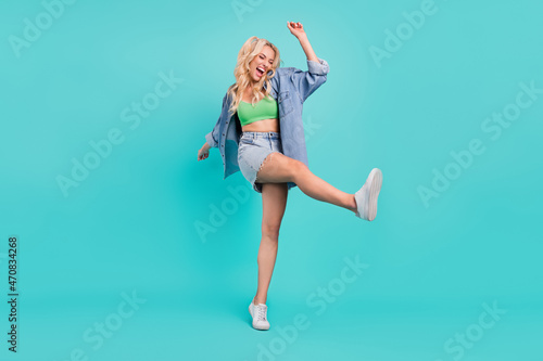 Fototapeta Naklejka Na Ścianę i Meble -  Full body photo of cheerful crazy happy woman raise leg good mood smile isolated on blue color background