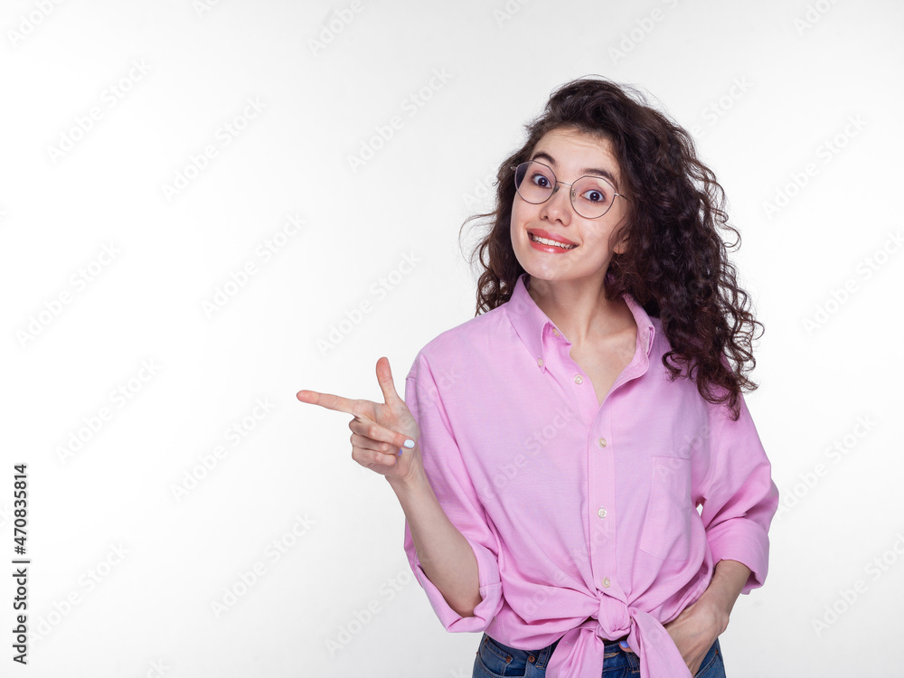 Portrait of a happy young Asian woman standing isolated against a white wall in the studio. The looking camera shows how the copy space points. Portrait of a happy young Asian woman standing isolated against a white wall in the studio. The looking camera shows how the copy space points.
